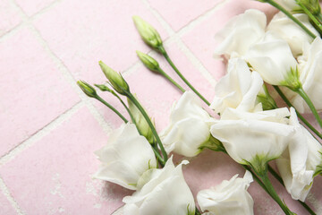Obraz na płótnie Canvas White eustoma flowers on color tile background, closeup