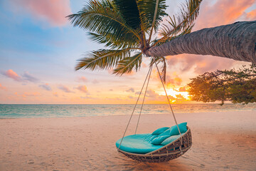 Romantic beach sunset. Palm tree with swing hanging before majestic clouds sky. Dream nature landscape, tropical island paradise, couple destination. Love coast, closeup sea sand. Relax pristine beach