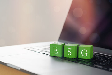 Wooden cubes with target setting to ESG icon with other ESG icons on computer. Copy space. ESG concept of environmental, social and governance. Sustainable corporation development..