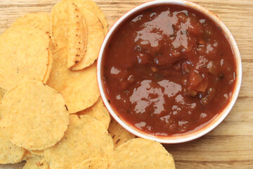 a bowl of chips and salsa on table ,