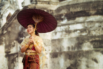 asian woman holding bamboo umbrella standing in old temple at ayutthaya world heritage site of unesco thailand