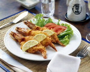 fried and breaded prawns with tomatoes and lettuce