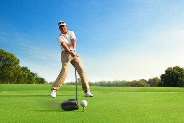 Motion action of golfer teeing off with drivers.