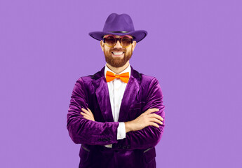 Portrait of man wearing funny costume. Studio shot of happy bearded guy in purple fedora hat,...