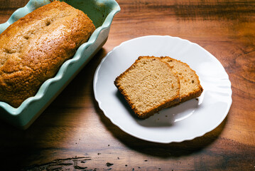 Homemade sponge cake in blue ceramic mold on wooden table. Sliced Pound cake.