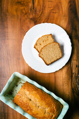 Homemade sponge cake in blue ceramic mold on wooden table. Sliced Pound cake.