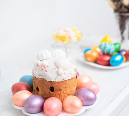 Painted Easter eggs with decorated Easter cake on white background close up with selective focus. Happy Easter concept
