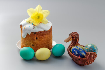 Easter cake and colorful Easter eggs in wicker basket.