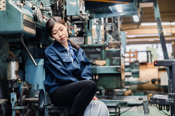 過労でやる気をなくす工場労働者の女性