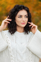 Autumn beauty female portrait of beautiful curly fashion woman in stylish vintage knitted sweater walks in fall golden park