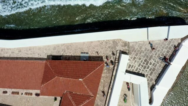 Rising bird's eye top aerial drone shot revealing the historic star shaped Reis Magos fort with waves crashing into the white walls in the beach capital city of Natal in Rio Grande do Norte, Brazil