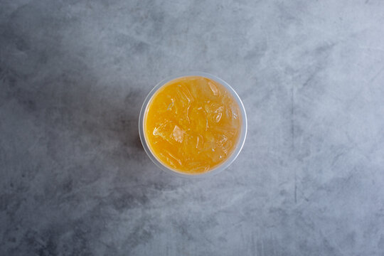 A Top Down View Of A Peach Green Tea Beverage.