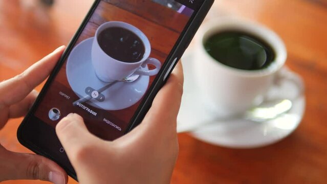 Female hands taking pictures of coffee for social networks.