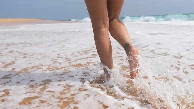 Female legs walking on water waves.