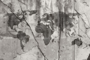 Weathered dark gray world map painted on a cracked wall with bullet holes. High resolution full frame textured background in black and white. Copy space.