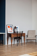 Table in retro style. Table lamp and abstract paintings. Armchair and other interior items. Design.