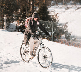 Portrait of a woman riding a bicycle in winter.