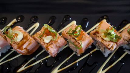 Salmon Oyako Spicy roll consist of crispy salmon skin is wrapped with sushi rice, topped with half...