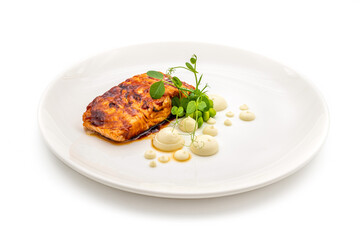 Grilled salmon fillet with sauces next to it on a white porcelain plate