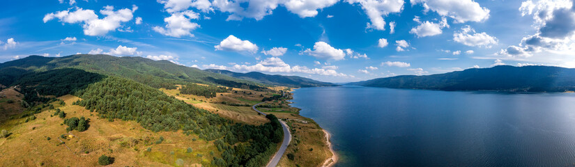 Fototapeta na wymiar Spectacular aerial view from a drone to a lake , hills, and a road between.