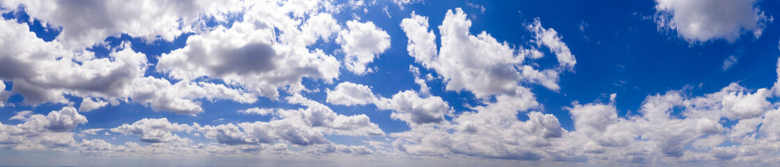 Naklejka na ściany i meble Panoramic view of blue sky with clouds and sunlight