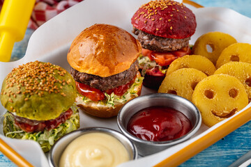 three mini burgers with chicken and meat served with french fries. kids menu