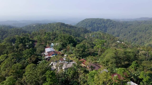 Aerial shot of La Conquista village in San Marcos Guatemala, moving upwards and forwards, revealing the surrounding forest and mountains.