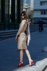 A girl in sunglasses walks the streets of the city
