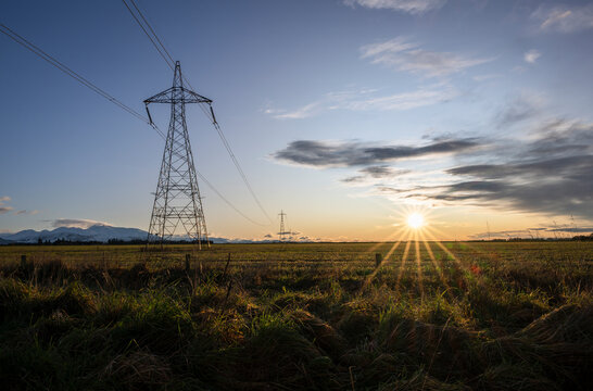 High voltage power pylon towers and powerlines at sunrise, Canterbury, South Island