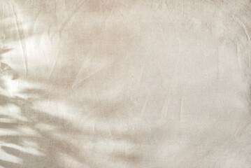 Abstarct floral natural background with foliage sunlight shadows on beige textile, copy space © Viktoriia