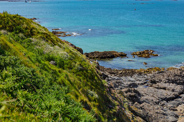 beautiful view from the island towards the sea, small islets and a green slope, Saint Malo, France