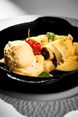 Pancakes stuffed with poppy and ice cream in a plate. White tablecloth background. Ukrainian Blini.