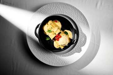 Pancakes stuffed with poppy and ice cream in a plate. White tablecloth background. Ukrainian Blini.