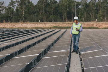 View on the rooftop solar power plant with mann walking and examining photovoltaic panels. Concept of alternative energy and its service