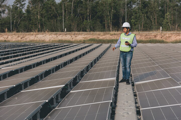 View on the rooftop solar power plant with mann walking and examining photovoltaic panels. Concept of alternative energy and its service