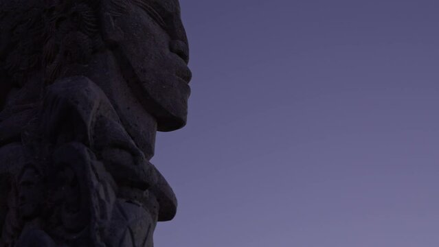 Close-up at night time of a Maori stone carving statue in Wellington, New Zealand