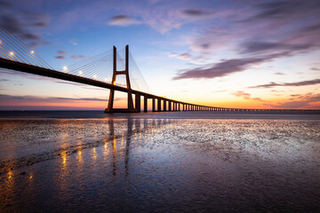 Vasco Da Gama bridge over Tagus River against sky during sunset
