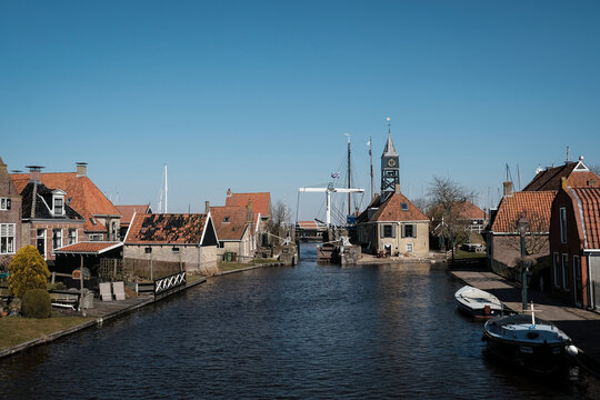 Canal amidst houses against clear sky in town