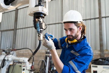 Technician repair robotic arm in workshop. Engineer maintenance automatic robotic arm machines in...