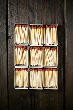 Overhead view of matchsticks in boxes on wooden table