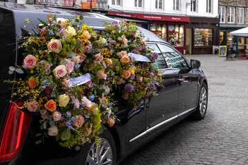 Hearse with floral wreath.