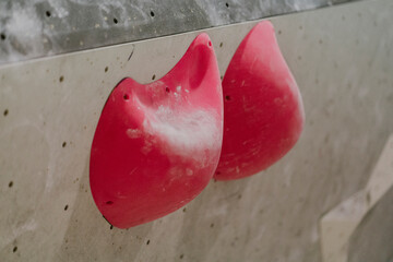 Close-up of red grips on climbing wall in health club