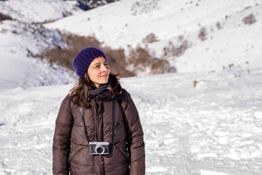 Portrait of a woman standing on snow covered mountain looking away