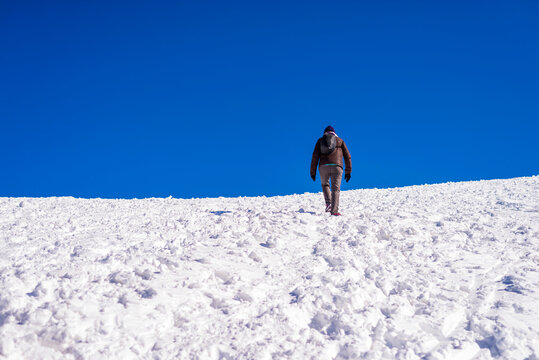 ear view of woman walking on snow covered field against sky