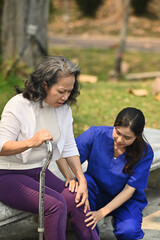 Professional caregiver taking care of elderly woman during walking in rehabilitation center. Assistance, rehabilitation and health