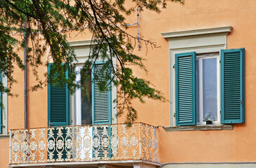 Fototapeta na wymiar A fragment of the facade of a house with a white balcony