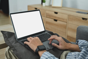 Close up view of man typing on laptop computer with blank white screen. Distance online study and freelance work concept