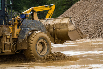 Front end loader dumping stone and sand in a mining quarry