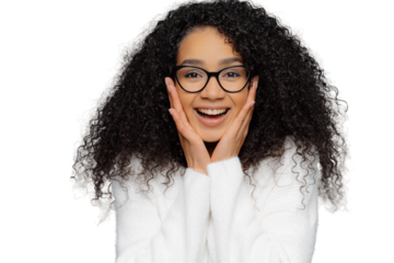 Close up shot of delighted African Amerrican woman touches both cheeks with hands, expresses positive emotions, wears transparent glasses and white sweater, happy to receive present of compliment