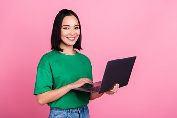 Photo of positive adorable girl with bob hairdo dressed green t-shirt holding laptop online...
